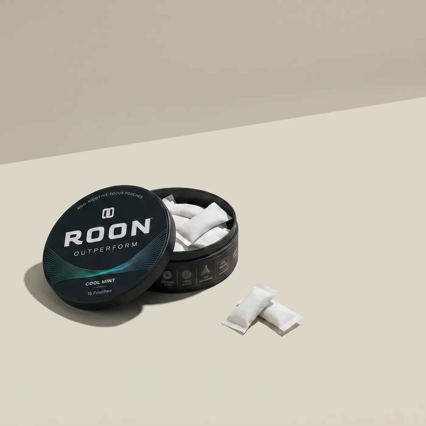 An open tin of Roon Cool Mint pouches on a bright desk beside a closed laptop and a notebook.