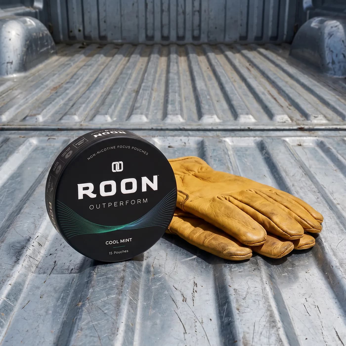 A closed tin of Roon Cool Mint pouches on a workbench beside a folded pair of work gloves.