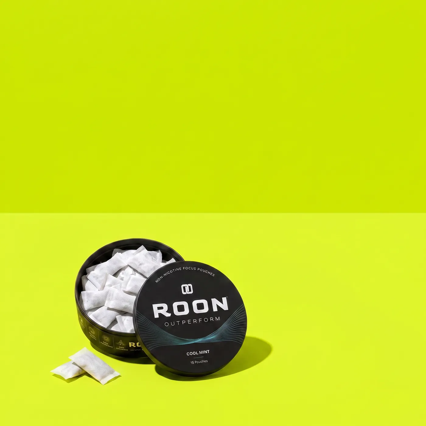 An open tin of Roon Cool Mint pouches on a bench beside a water bottle in a bright gym.