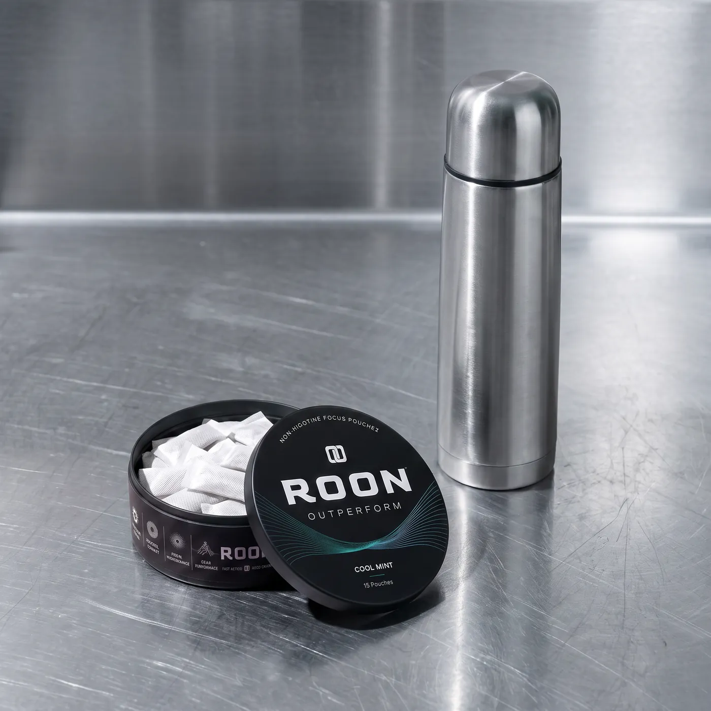 An open tin of Roon Cool Mint pouches on a bright break room counter beside a stainless flask.