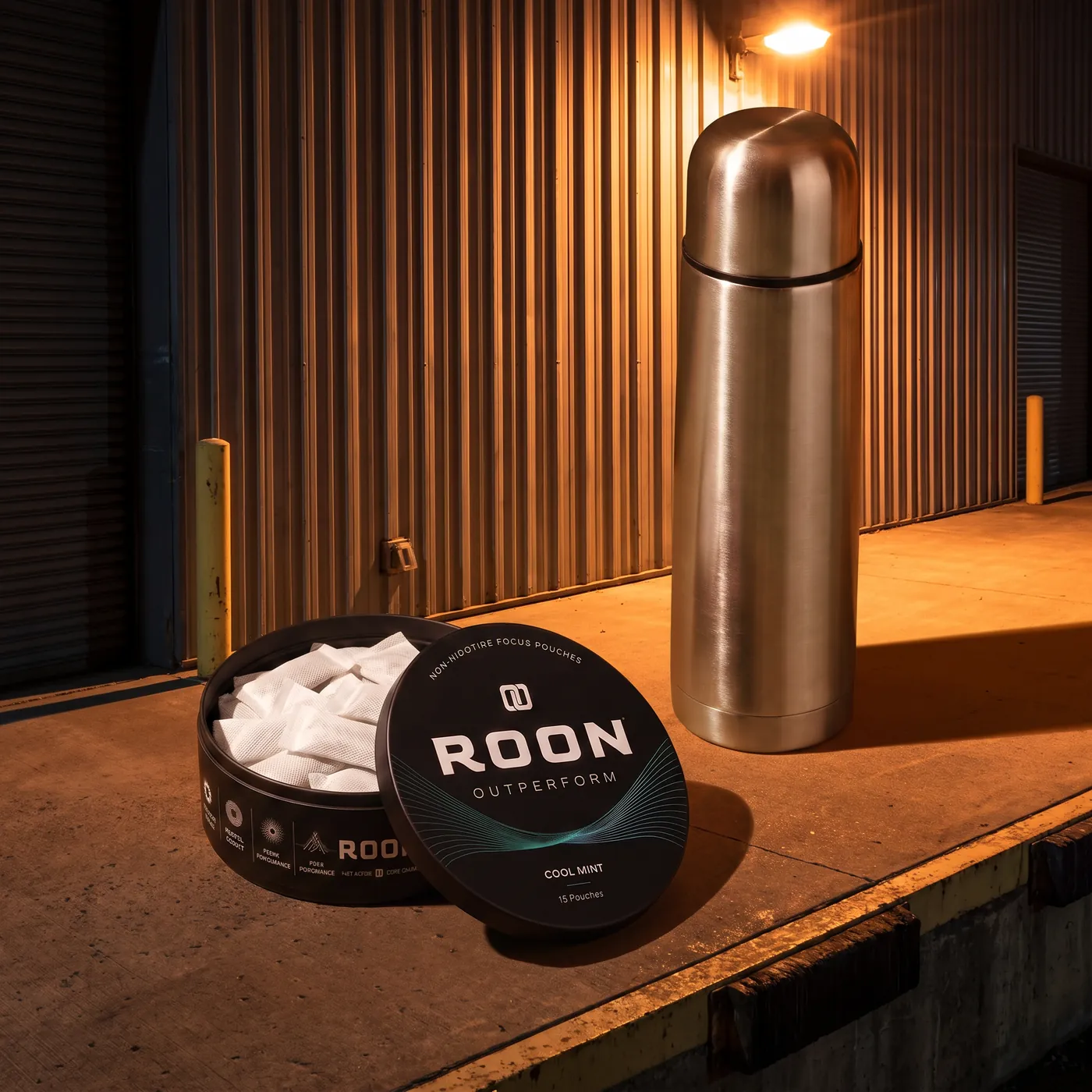 An open tin of Roon Cool Mint pouches on a bright break room counter beside a stainless flask.