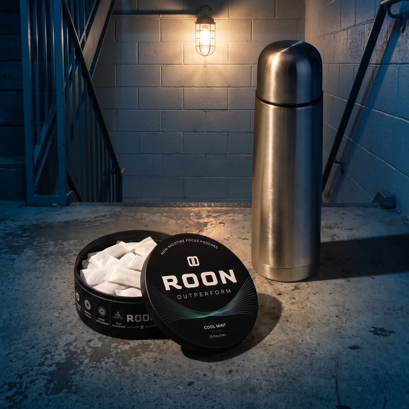 An open tin of Roon Cool Mint pouches on a bright break room counter beside a stainless flask.