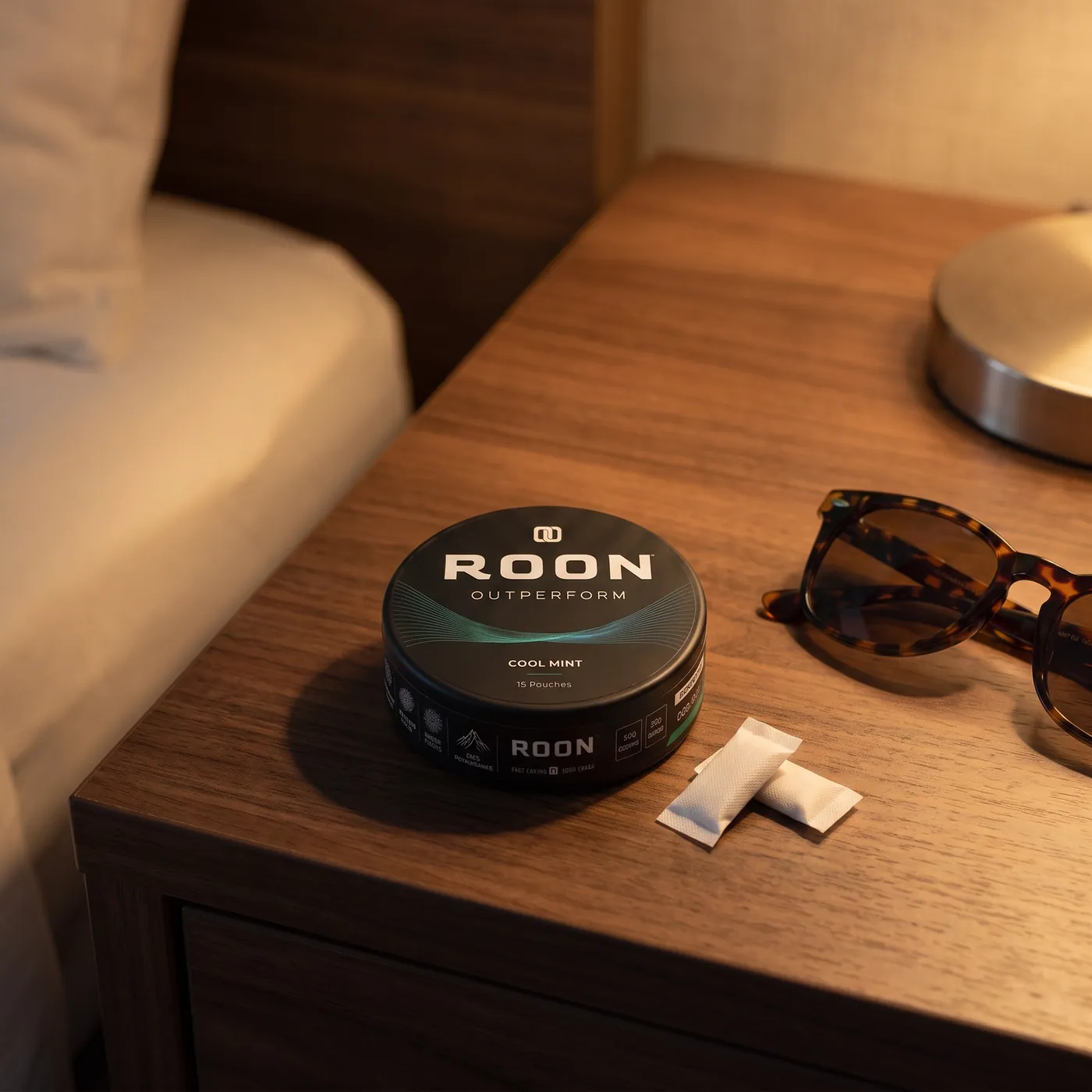 A closed tin of Roon Cool Mint pouches on an aircraft tray table in bright cabin daylight.