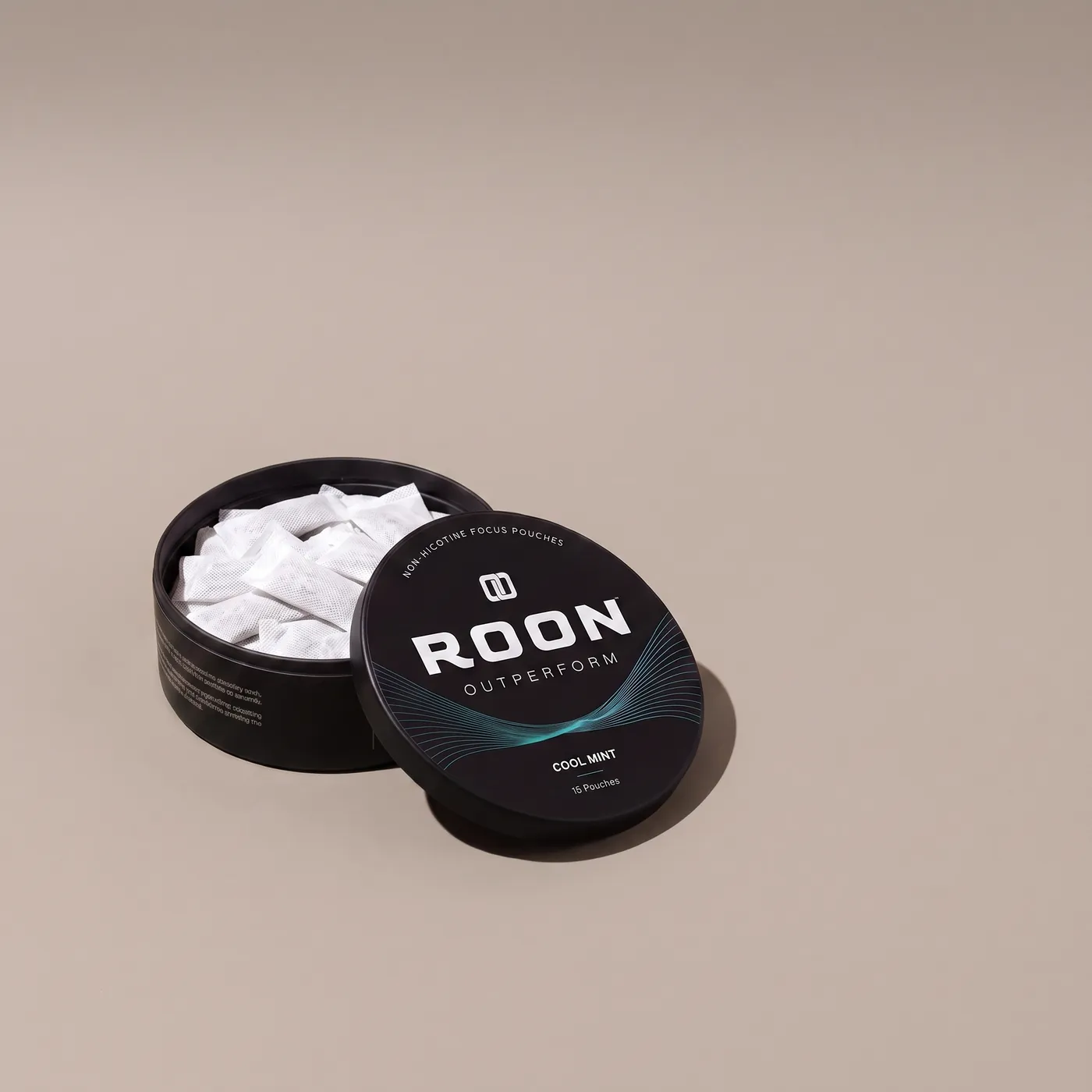 An open tin of Roon Cool Mint pouches beside an empty espresso cup, comparing a pouch to a cup of coffee.