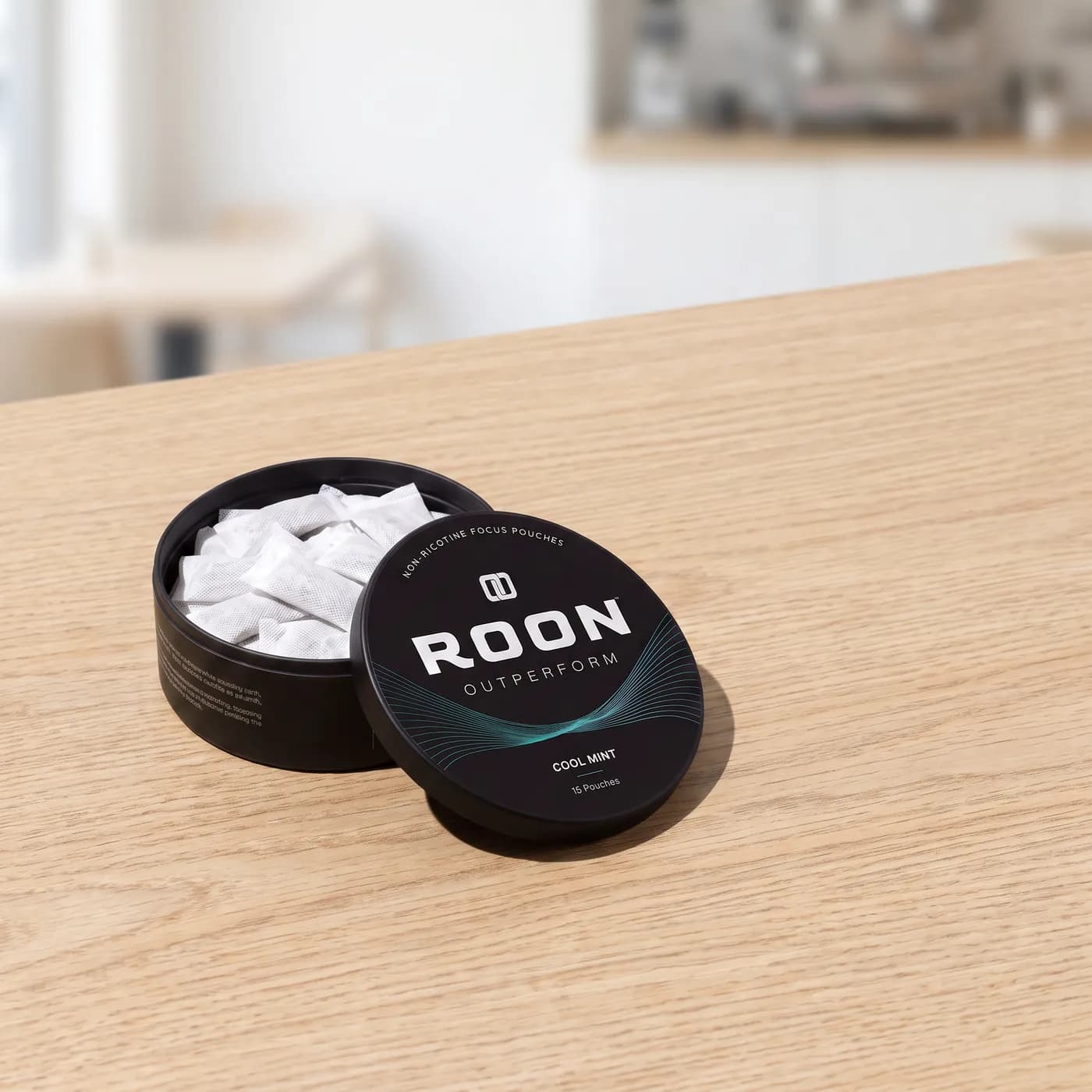 An open tin of Roon Cool Mint pouches beside an empty espresso cup, comparing a pouch to a cup of coffee.