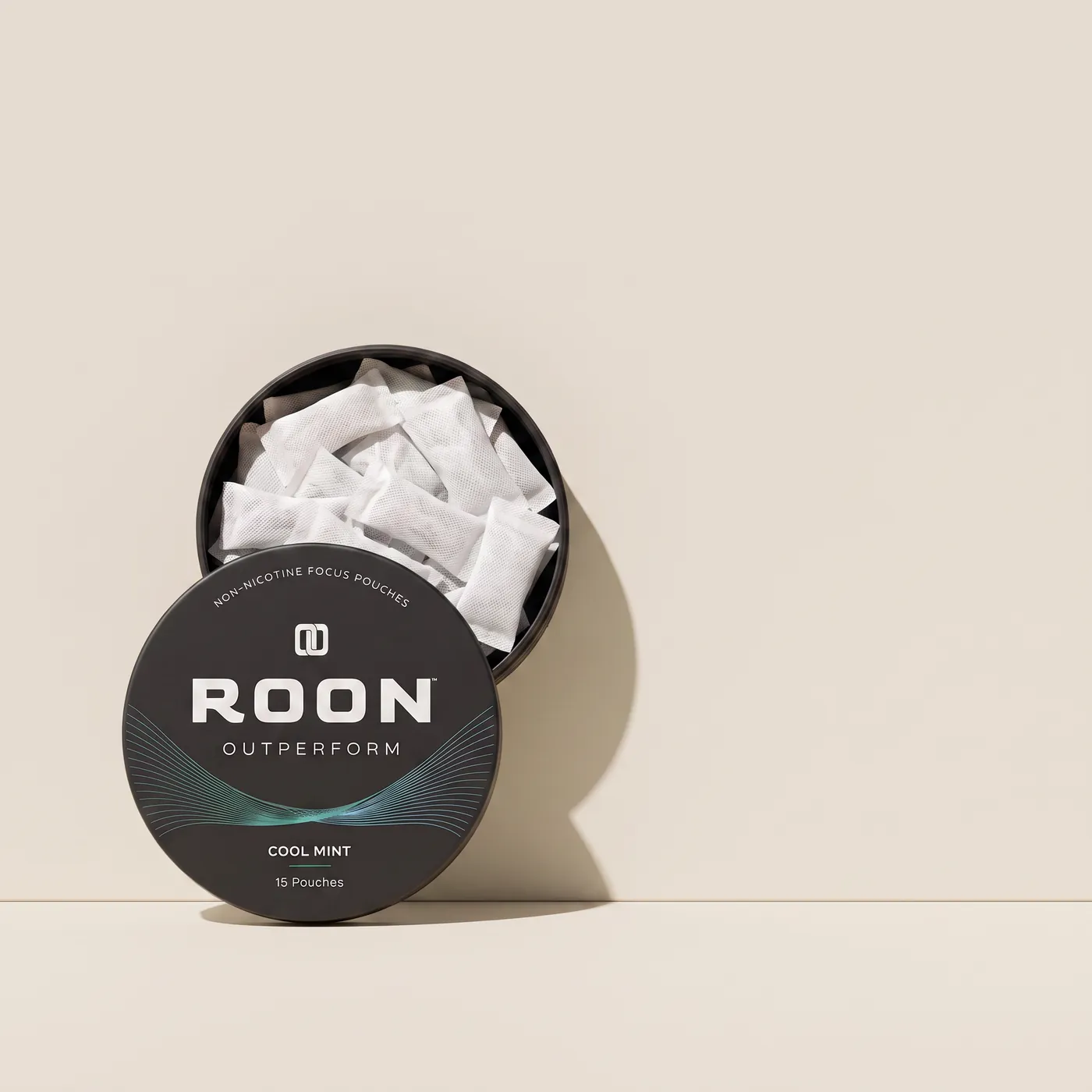 An open tin of Roon caffeine pouches in front of a plain slim energy drink can, comparing the two formats.