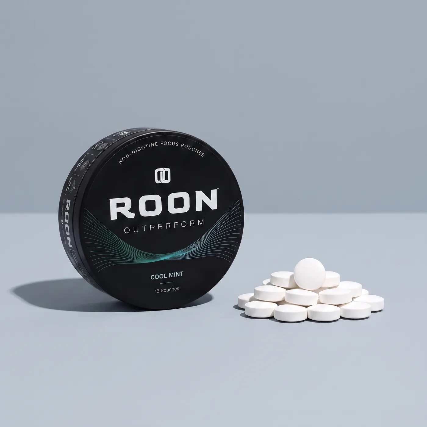 An open tin of Roon caffeine pouches next to loose caffeine tablets, comparing the two formats.