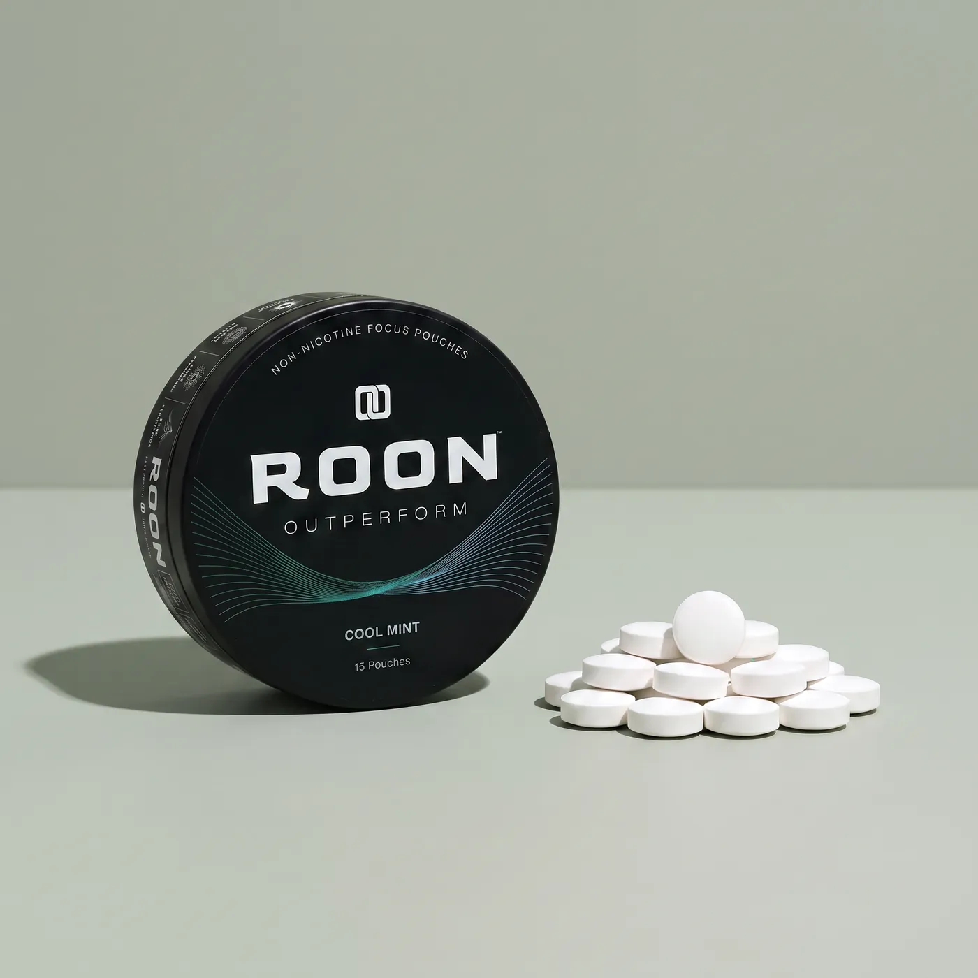 An open tin of Roon caffeine pouches next to loose caffeine tablets, comparing the two formats.