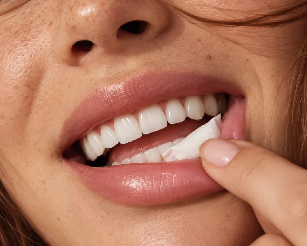 A person placing a Roon pouch against their gum
