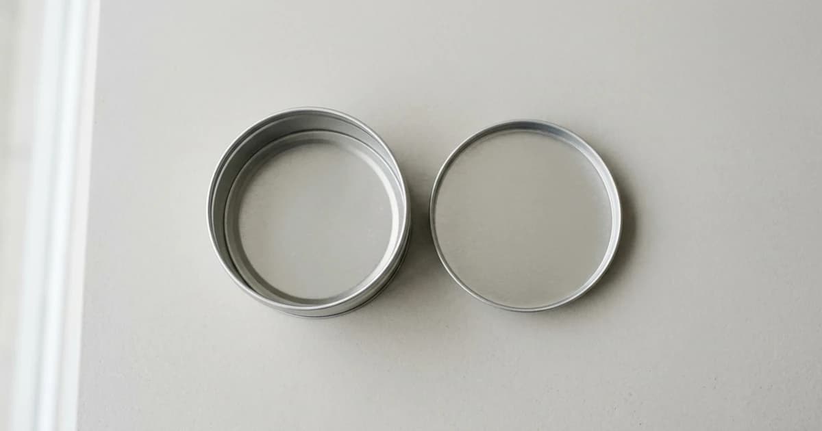 A plain open tin viewed from above on a clean neutral surface